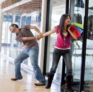 Man keeping a woman from entering a store Man keeping a woman from entering a store