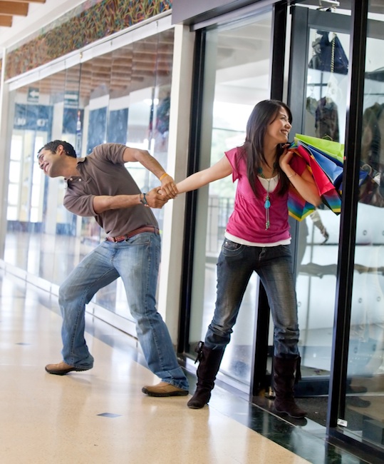Man keeping a woman from entering a store